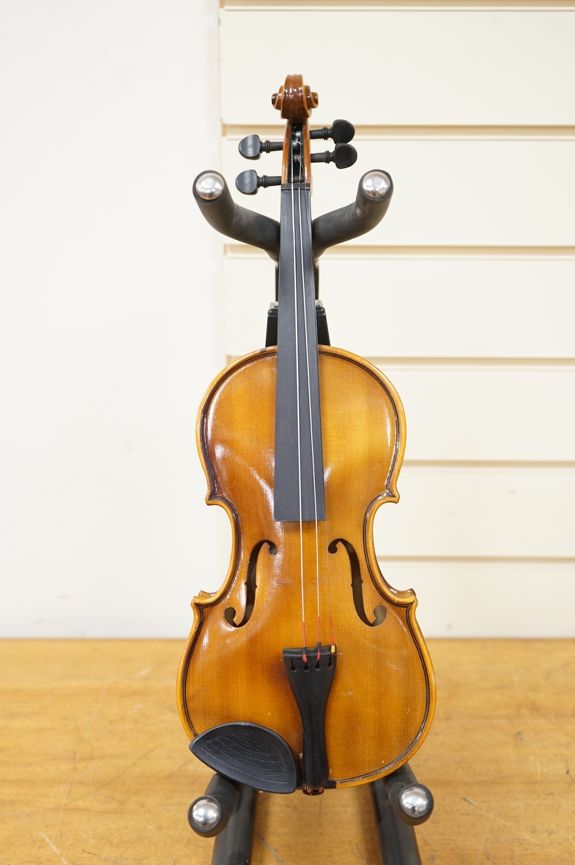 Five cased 20th century violins, including; a German violin, two Czech violins, a three-quarter size violin with a label for Bienfait, and a Romanian quarter size violin, all in cases or the remains of cases.